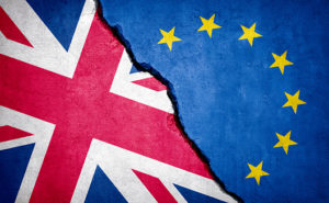 Brexit Concept. United Kingdom And EU Flag On Broken Wall.